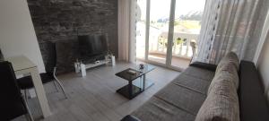 a living room with a couch and a tv at Apartments M&M in Baška