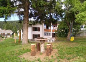 - une table de pique-nique devant une maison arborée dans l'établissement Pisolo Cottage, à Ronzone