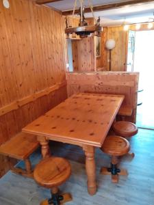 - une table et des chaises en bois dans l'établissement Pisolo Cottage, à Ronzone