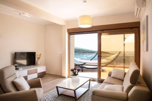 a living room with a couch and a tv and a hammock at Royal Bay in Dobra Voda