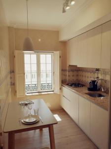 a kitchen with a table and a window in it at Casa do Quico in Nazaré +29 photos
