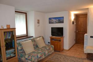 a living room with a couch and a flat screen tv at Alle pendici del Monte Rosa in Champoluc