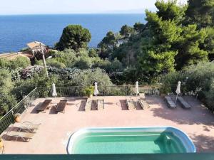 a swimming pool with lounge chairs and the ocean at Syraino in Kolios