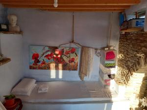a room with a bed and a painting on the wall at Katerina's Sunset in Panormos