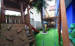 a playground with a wooden play structure with a tree at Vila Wolf in Jupiter