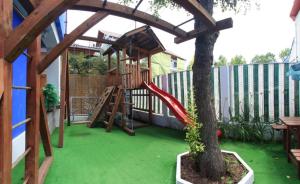 a playground with a slide and a tree at Vila Wolf in Jupiter