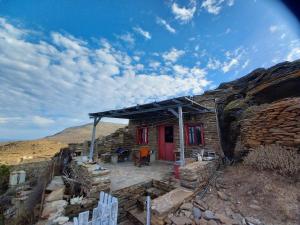 a small house with a red door on a mountain at Katerina's Sunset in Panormos