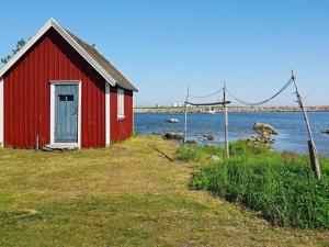 un edificio rojo sentado junto a un cuerpo de agua en 5 person holiday home in S LVESBORG, en Sölvesborg