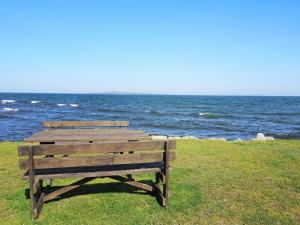 dos bancos de madera sentados en el césped cerca del océano en 5 person holiday home in S LVESBORG, en Sölvesborg