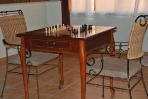 um jogo de xadrez numa mesa de madeira com duas cadeiras em Honny - Boutique Hotel em Amirim