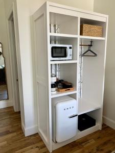 a white cabinet with a microwave and a refrigerator at The Inn in Buena Vista