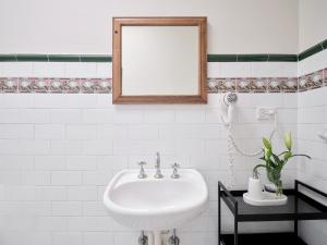 a bathroom with a white sink and a mirror at Dunkirk Hotel Pyrmont in Sydney