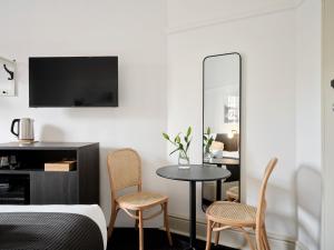 a bedroom with a table and two chairs and a mirror at Dunkirk Hotel Pyrmont in Sydney