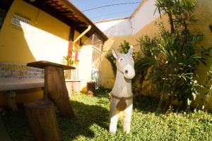 a statue of a donkey standing in the grass at Pousada Viva Ubatuba - GRUPO VIVA UBATUBA in Ubatuba +208 photos