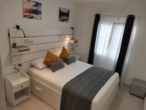 een kleine slaapkamer met een bed en een raam bij White Suite Deluxe in Costa Teguise