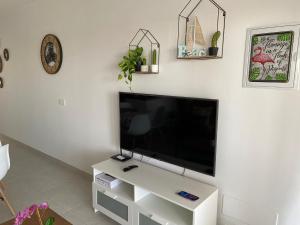 een woonkamer met een flatscreen-tv aan de muur bij White Suite Deluxe in Costa Teguise