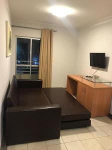 a living room with a couch and a desk at Apartamento mobiliado para temporada-Rio Quente in Rio Quente