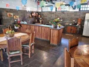 a kitchen with wooden tables and chairs and a counter at Pousada Bosque Encantado in Bragança Paulista
