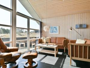 ein Wohnzimmer mit Sofas, einem Tisch und Fenstern in der Unterkunft Holiday home Fanø CLXXXVI in Fanø
