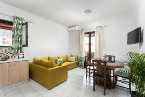 uma sala de estar com um sofá amarelo e uma mesa em Monemvasia Green Apartments em Monemvasia