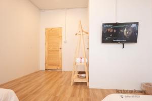 a room with a flat screen tv on a wall at Petra Boutique Donmuang in Bangkok