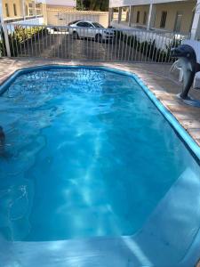 ein großer blauer Pool mit Delfin in der Unterkunft PORTO GALINHAS TODO MOBILIADO 5 minutos a pé da praia in Porto De Galinhas