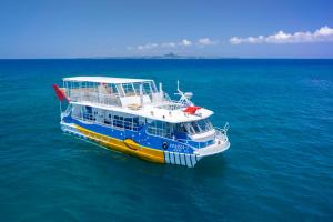 a blue and yellow boat in the water at Marine Piazza Okinawa in Motobu