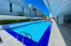 uma grande piscina azul num edifício em 229 Flat no Imperial Tambaú beira mar em João Pessoa