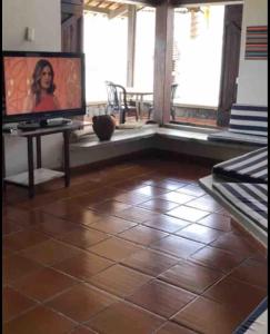 a living room with a tiled floor and a flat screen tv at CASA À BEIRA MAR EM PRAIA DE CAMPINA in Rio Tinto