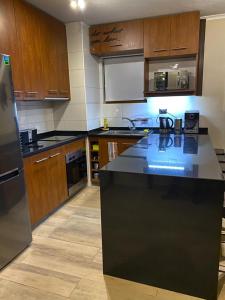 a kitchen with wooden cabinets and a black counter top at Valle Nevado Vip Apartment Ski Out-In in Valle Nevado