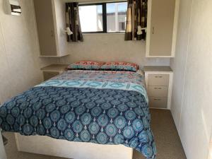 a bedroom with a bed with a blue comforter at Te Puru B8 - 2 bedroom chalet in Te Puru