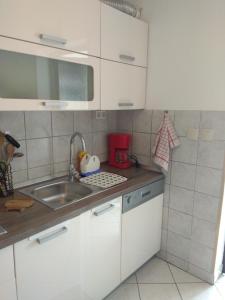 a kitchen with white cabinets and a sink at Apartment Nebo in Poreč