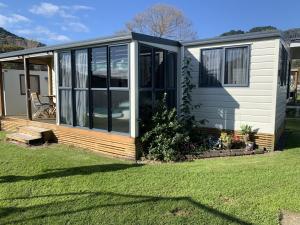 uma casa móvel com portas de vidro deslizantes num quintal em Te Puru B8 - 2 bedroom chalet em Te Puru