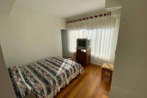 - une chambre avec un lit et une télévision dans l'établissement Tower Center Apartment, à La Paz