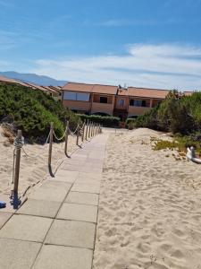 a walkway on the beach next to a building at Endless Summer in Badesi