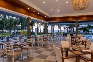 a restaurant with tables and chairs and a view of the ocean at Sunprime Kamala Beach in Kamala Beach