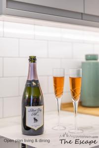 - deux verres de bière assis à côté d'une bouteille de vin dans l'établissement The Escape; the ideal getaway on Brighton seafront, à Brighton et Hove