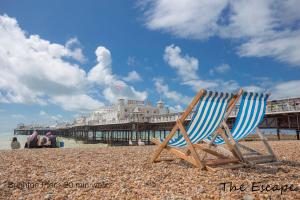 une paire de chaises assises sur une plage avec une jetée dans l'établissement The Escape; the ideal getaway on Brighton seafront, à Brighton et Hove