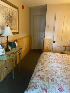 1 dormitorio con 1 cama y 1 mesa con lámpara en Gunn House Hotel, en Sonora