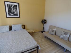 a bedroom with two beds and a couch at GEORGES IPSOS APARTMENTS in Ipsos