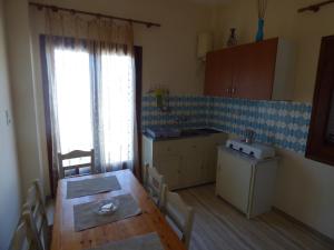 a kitchen with a wooden table and a dining room at GEORGES IPSOS APARTMENTS in Ipsos
