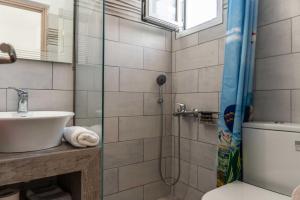 a bathroom with a shower and a toilet and a sink at SKYROS AVRA Residences in Skiros