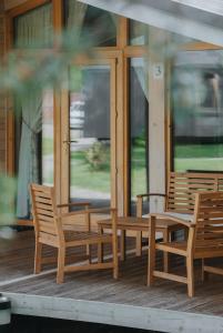 two wooden chairs sitting on the porch of a house at Talitsy Lodge in Talitsa