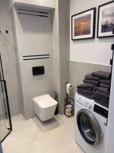 een badkamer met een wasmachine en een toilet bij Apartament Sosnowa 4 in Mielno