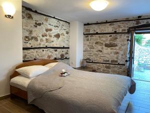 a bedroom with a bed and a stone wall at Elia & Meli Studio in Kallirákhi