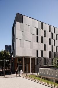 two people walking in front of a building at Alex Hotel in Perth