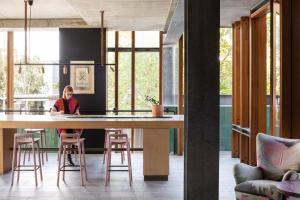 a woman sitting at a large table in a kitchen at Alex Hotel in Perth