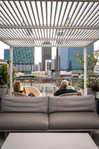 a group of people sitting in chairs on a balcony at Alex Hotel in Perth