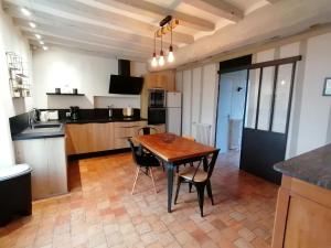 uma cozinha com mesa e cadeiras num quarto em Gîte Cossé-le-Vivien, 5 pièces, 8 personnes - FR-1-600-113 em Cossé-le-Vivien
