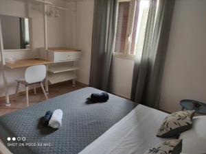 una camera con un letto con due cappelli e una scrivania di La casa dei fico d'india a Marina di Ragusa